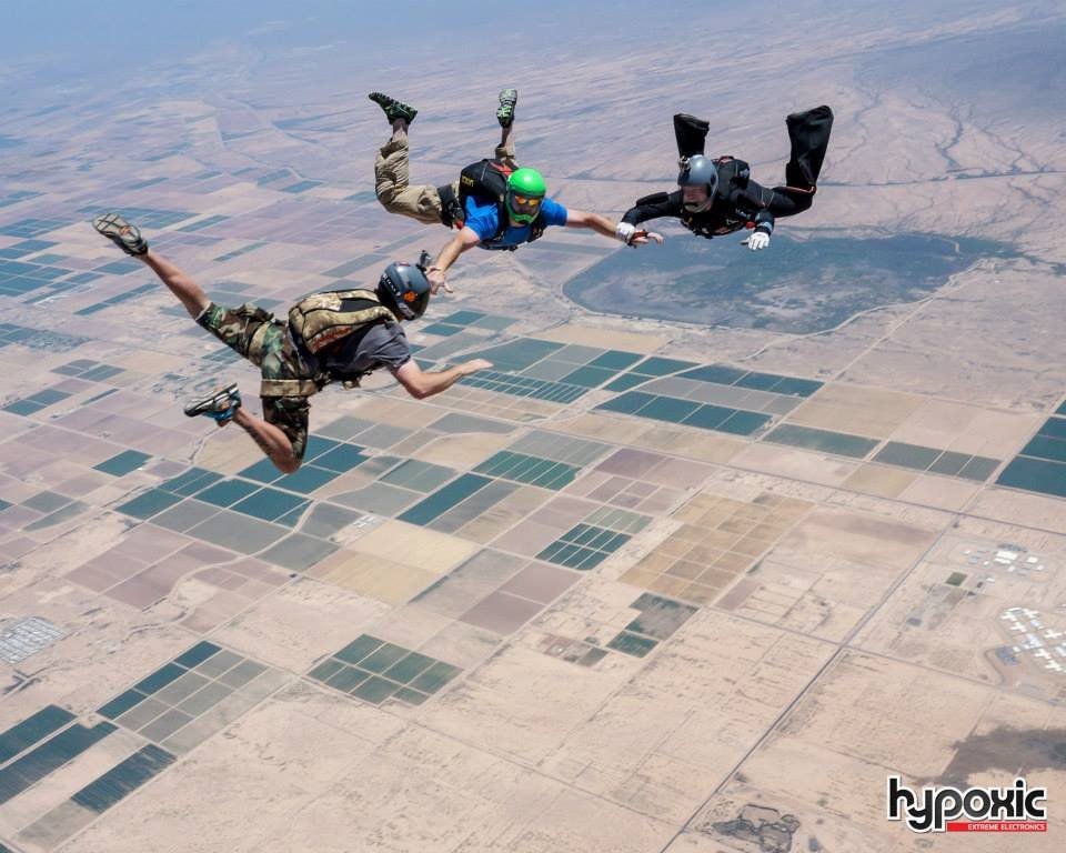 Mark Farmer in freefall with two other skydivers over the Arizona desert