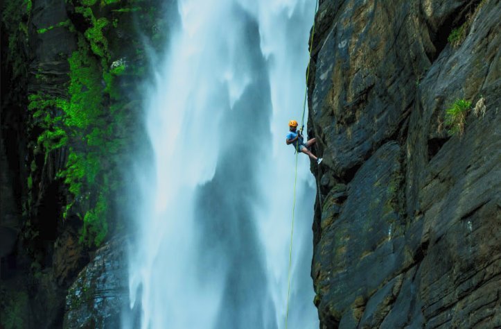 Rappelling beside a massive waterfall