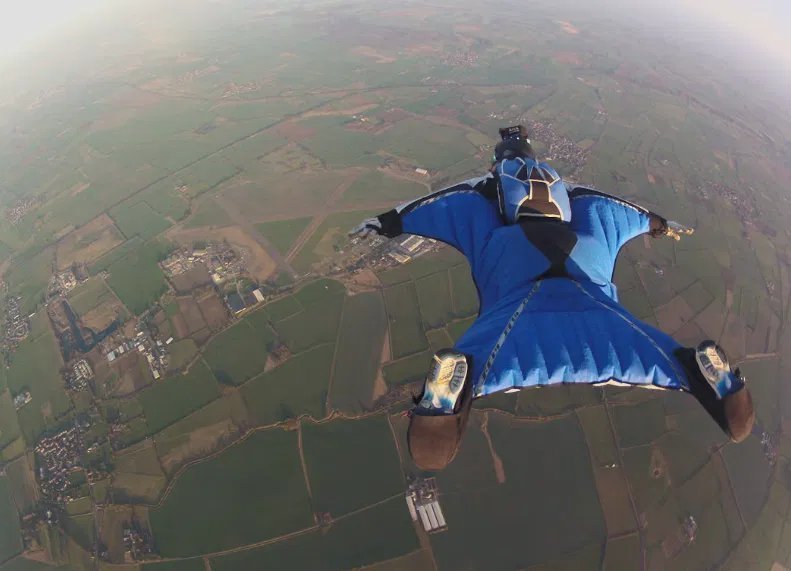 Wingsuit flight over open countryside